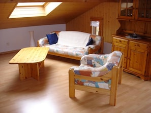 A loft-style room with a wooden floor, a sofa, a small table, and a cabinet. - Chalet Sunneschyn Appartement/Fewo, Dusche oder Bad, WC 2-Bett Wohnung by Interhome (Schwanden ob Sigriswil)