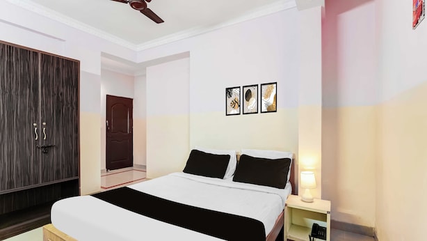A hotel room with a bed, bedside table, lamp, and a ceiling fan. - Townhouse Bangalore Goraguntepalya (Bengaluru)