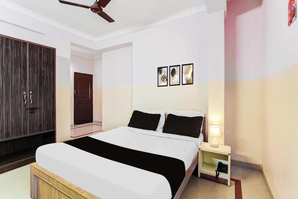 Ein Hotelzimmer mit Bett, Nachttisch, Lampe und Deckenventilator.