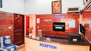 A reception area with a counter, a framed picture above it, a wall calendar, and a door labeled '004'. - Townhouse Bangalore Goraguntepalya (Bengaluru)