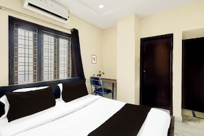 Una habitación de hotel con una cama, un escritorio y una ventana con cortinas.