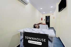 Zona de recepción con mostrador de mármol con la leyenda 'TOWNHOUSE & Company-Serviced'.