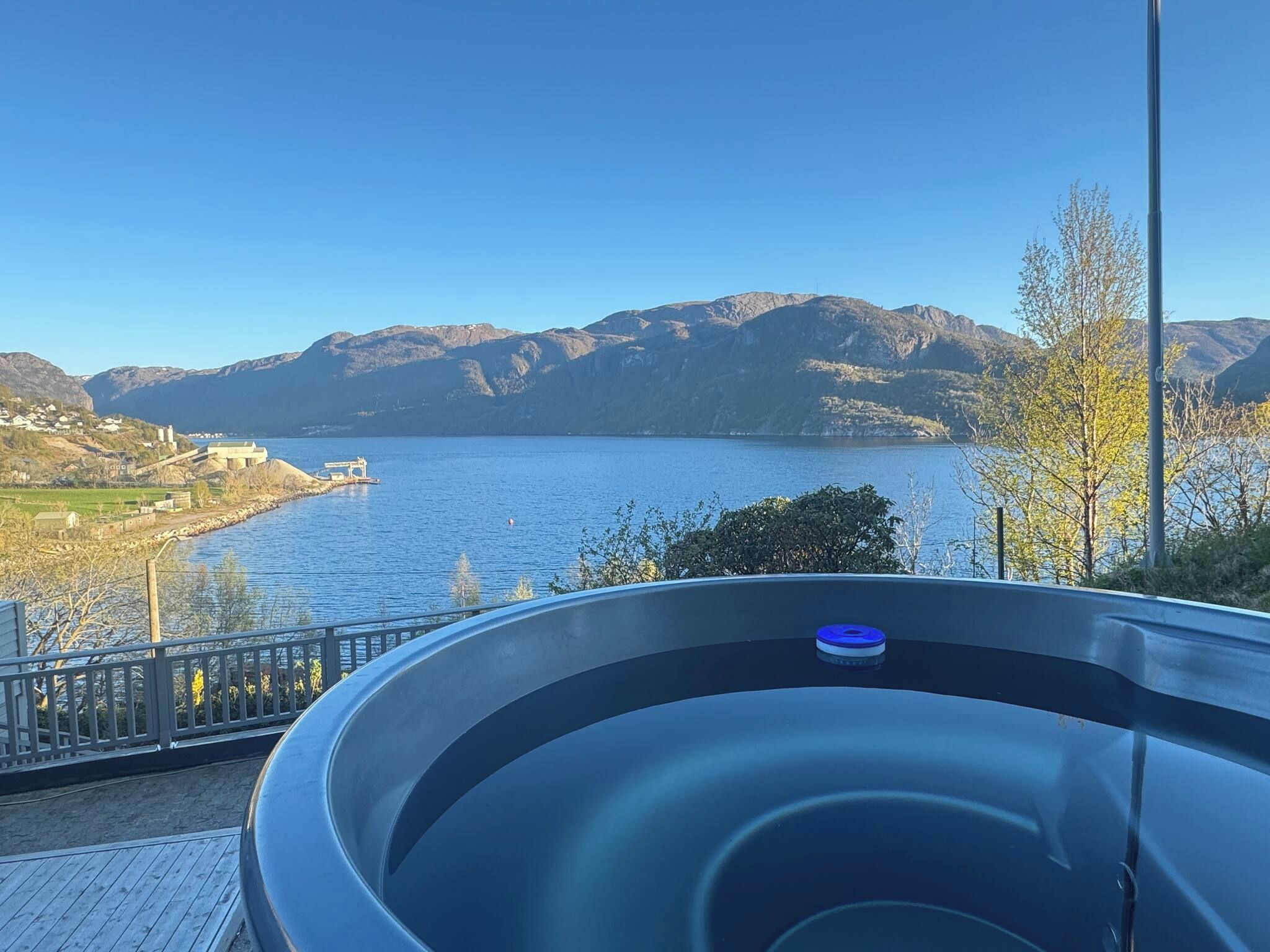 A hot tub with a view of a lake and mountains.