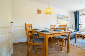 Ein Essbereich mit Holztisch, Stühlen und einer Pendelleuchte.