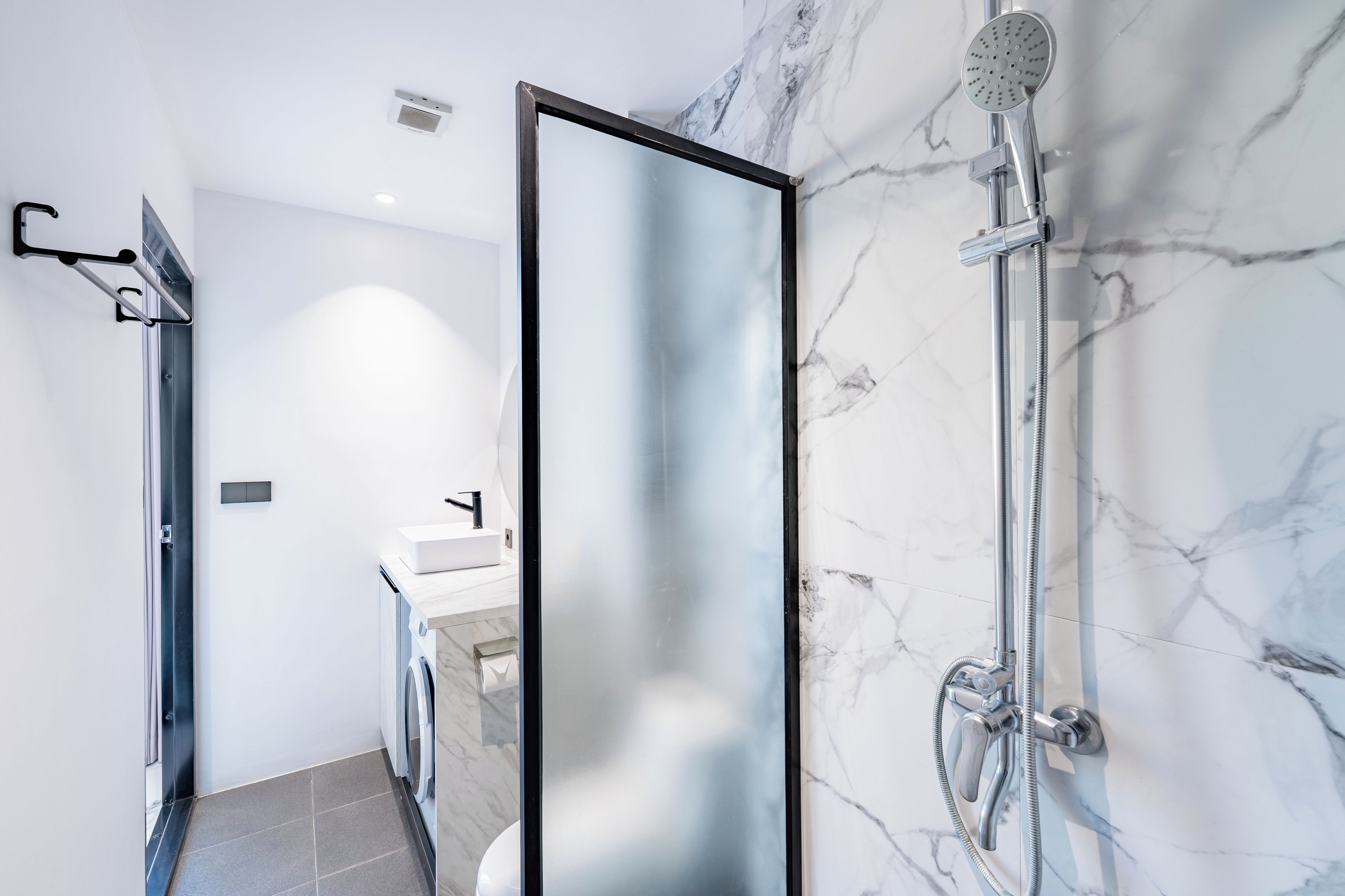 A modern bathroom with a shower, a toilet, and a sink.