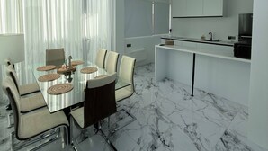 A modern kitchen with white cabinetry and a built-in microwave. - Sun On the Hill Villa by Betterplace (Nusa Dua)