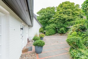 En vit byggnad med en asfalterad uppfart som leder till en överbyggd entré.