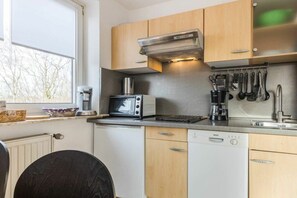 Eine kleine Küche mit Mikrowelle, Toaster und Kaffeemaschine.
