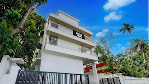 A multi-story hotel with a sign reading 'HOTEL' and balconies. - Townhouse Valiyavila Bus Terminal (Trivandrum)