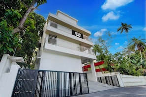 Un hôtel à plusieurs étages, avec une enseigne indiquant « HÔTEL » et des balcons.
