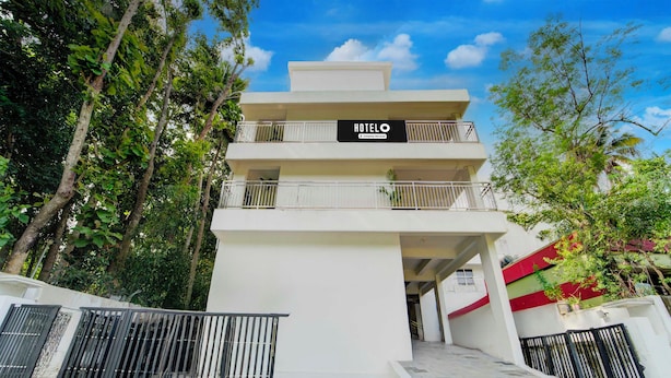A multi-story hotel with a sign reading 'HOTEL' and 'Company Serviced.' - Townhouse Valiyavila Bus Terminal (Trivandrum)