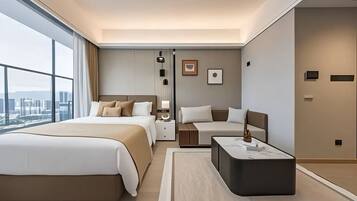 Quarto de hotel moderno com uma cama grande, um sofá menor, uma mesa de cabeceira e vista para a cidade.