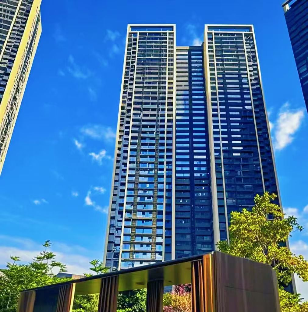 A high-rise building with a modern architectural design, featuring a grid of windows and a central core.