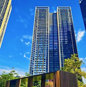 Um edifício alto com design arquitetônico moderno, destacando uma grade de janelas e um núcleo central.