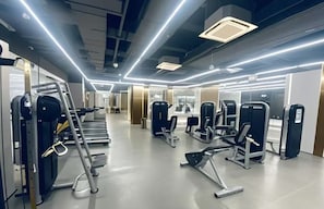 Un gimnasio moderno con diversos equipos de ejercicio, incluyendo cintas de correr y máquinas de pesas.