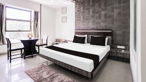 Une chambre d’hôtel moderne avec un grand lit, un bureau et une chaise.