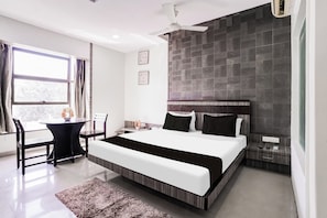 A modern hotel room with a large bed, a desk, and a chair. - Townhouse Kranti Square Aurangabad (Aurangabad)