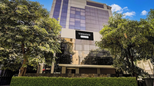Un immeuble moderne avec une enseigne indiquant : « TOWNHOUSE, services d’entreprise ».