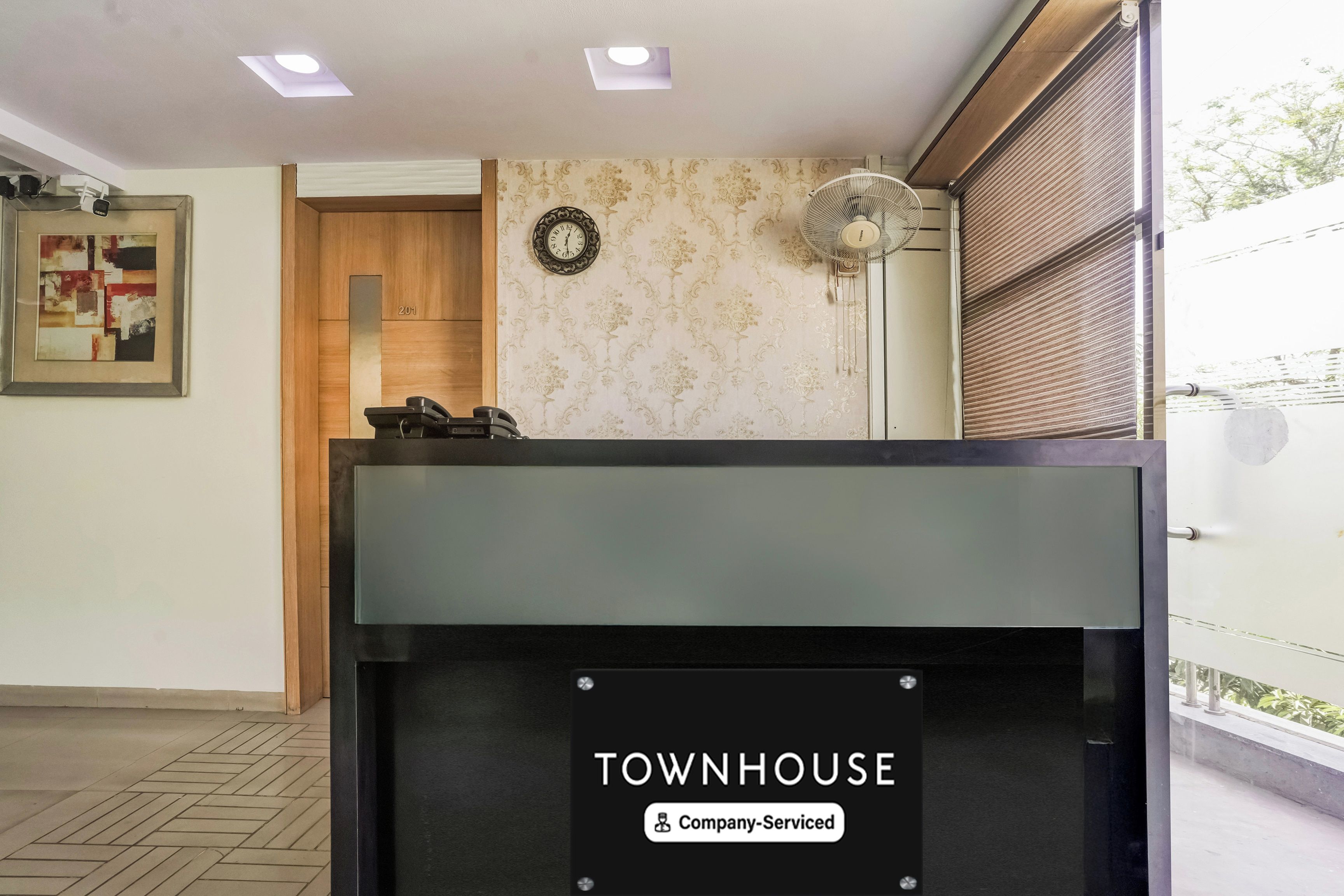 A reception desk with a sign reading 'TOWNHOUSE Company-Serviced.'