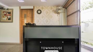 A reception desk with a sign reading 'TOWNHOUSE Company-Serviced.'