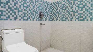 A bathroom with a toilet, a shower, and tiled walls.
