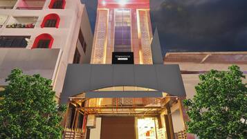 A modern building with a prominent entrance, a sign indicating it's a serviced company property, and a view of the interior through the entrance.