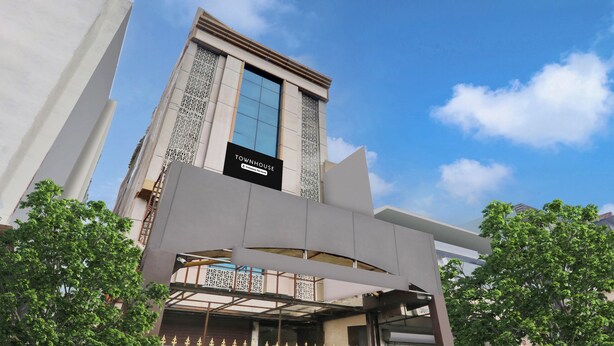 A modern building with a prominent sign reading 'TOWNHOUSE' and a gated entrance.