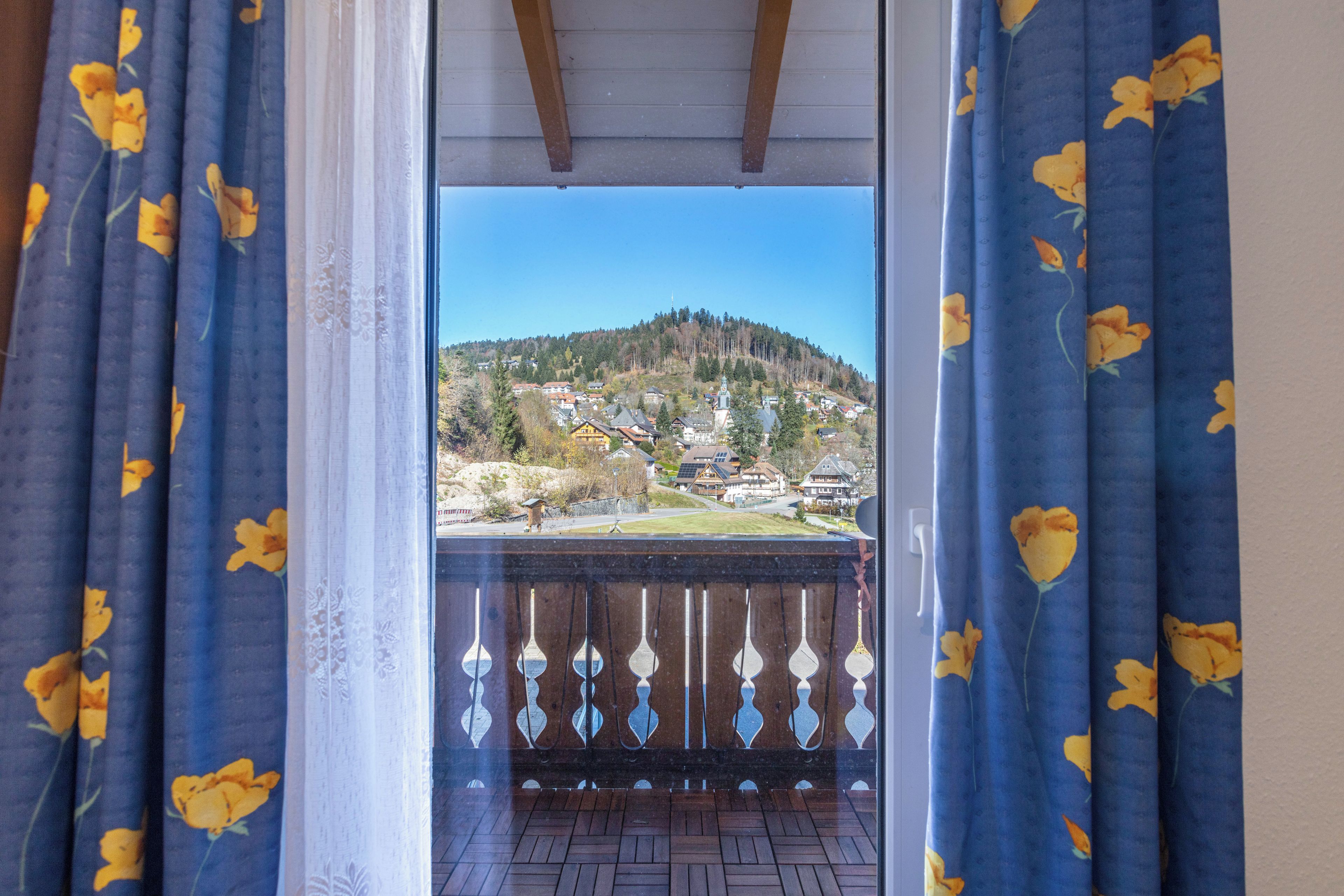 Un balcon donnant sur un village perché sur une colline.
