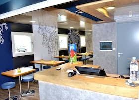 Un área de recepción con mostrador, asientos y una puerta.