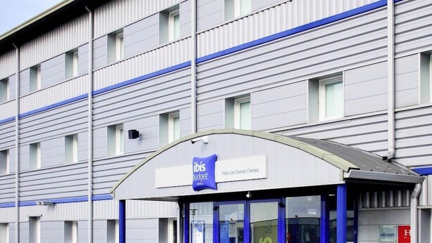 A hotel entrance with a blue and white facade, a sign for 'ibis budget,' and a visible ACCOR logo. - Ibis Budget Flers Grands Champs (Flers)