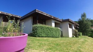 A modern two-story building with a flat roof, large windows, and a covered outdoor area. - Vvf Villages Parent (Parent)