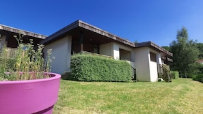 A modern two-story building with a flat roof, large windows, and a covered outdoor area. - Vvf Villages Parent (Parent)