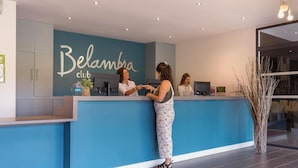 Een receptie met een blauw aanrecht, een bord met de tekst 'Belambra club' en een receptiebalie.