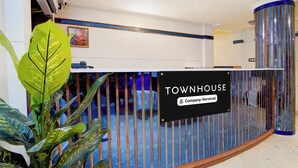 Un espace d’accueil avec une enseigne indiquant « TOWNHOUSE & Company, services inclus ».