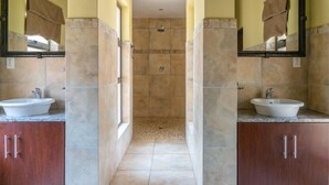 A bathroom with two sinks, a shower, and a mirror on each side. - Zebula Golf Estates & Spa (Bela-Bela)
