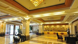 Un hall d’hôtel comprenant un comptoir d’accueil, un lustre et une statue d’éléphants.