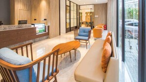 A modern reception area with a reception desk, seating area, and large windows. - Jinjiang Inn Shanghai East China Normal University (Shanghai)