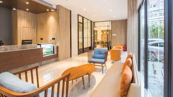 A modern reception area with a reception desk, seating area, and large windows.