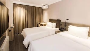 A hotel room with two beds, a desk, a chair, a lamp, and an air conditioning unit. - Jinjiang Inn Shanghai East China Normal University (Shanghai)