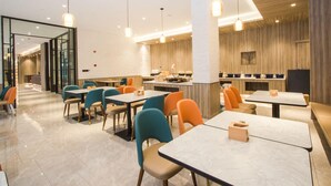 A modern restaurant interior with multiple dining tables and chairs, a kitchen area, and a glass partition separating the dining area from the kitchen. - Jinjiang Inn Shanghai East China Normal University (Shanghai)