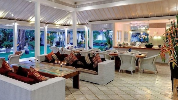 Un grand espace intérieur avec une piscine, un coin salon extérieur et un espace repas.