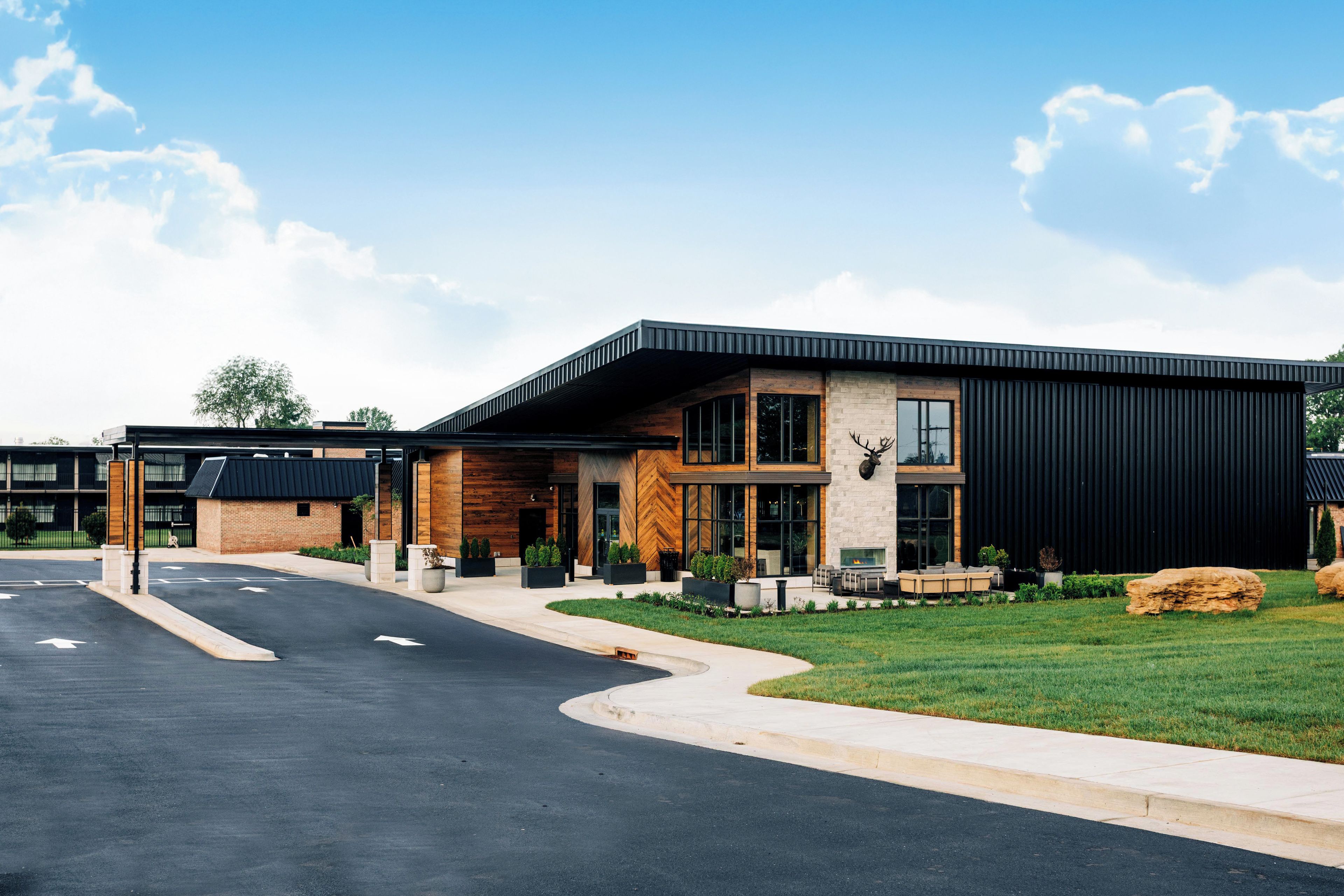 A modern building with a flat roof, large windows, and a stone facade.