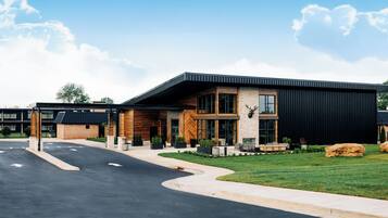 A modern building with a flat roof, large windows, and a stone facade.