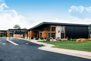 A modern building with a flat roof, large windows, and a stone facade. - Quality Inn Bardstown (Bardstown)