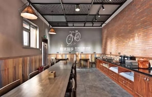A spacious dining area with a long wooden table, brick walls, and a ceiling with a grid pattern. - Time Walk Nostalgic Theme Hotel Beijing Prince Gongfu (Beijing)