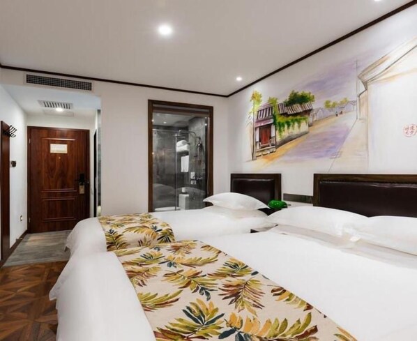 Una habitación de hotel con una cama grande, zona de ducha y un mural en la pared.