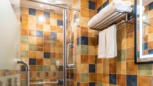 A bathroom with a glass shower enclosure, a white toilet, and a sink with a black countertop. - Time Walk Nostalgic Theme Hotel Beijing Prince Gongfu (Beijing)