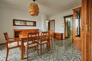 A dining area with a wooden table and chairs, a woven light fixture, and a kitchen visible through an open door. - Puerto Atarazanas Flat – Apartment in Valencia next to the Atarazanas (València)