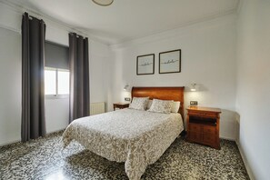 A bedroom with a bed, two bedside tables, a headboard, a window with curtains, and two framed inspirational quotes on the wall. - Puerto Atarazanas Flat – Apartment in Valencia next to the Atarazanas (València)