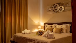 Una habitación de hotel con cama, almohadas, lámpara y toallas.